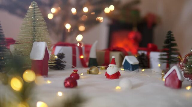 Santa claus doll with christmas decorations with blurred lights on christmas tree.
