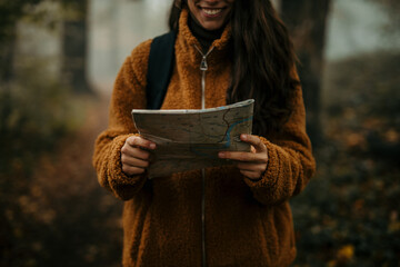 Woman hiking in forest looking at map