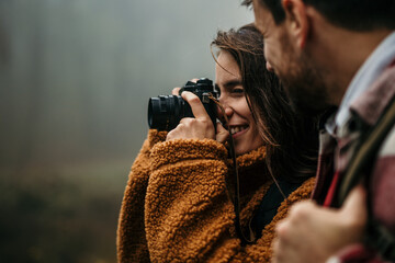 Happy woman taking pictures outdoor with man