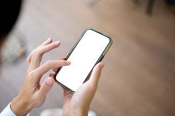 Close up man looking and touching on white screen phone in hand sitting indoors at wooden floor cafe