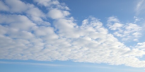 Wispy white clouds drift across a vibrant blue sky with a hint of thin cirrus clouds high above