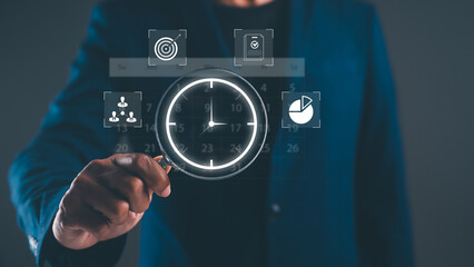 A person holds a magnifying glass over a digital clock, symbolizing analysis and time management in a modern, tech-driven environment.