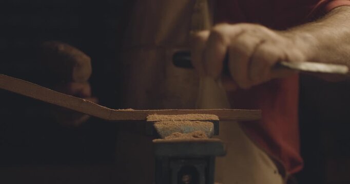 Man working with wood, making a tradional portuguese guitar, traditional carpentry, 4K slow motion