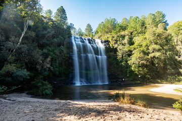 Obraz premium Majestic Mariquinha Waterfall (Cachoeira Mariquinha) cascading into a natural pool surrounded by dense forest in Ponta Grossa, Parana, Brazil