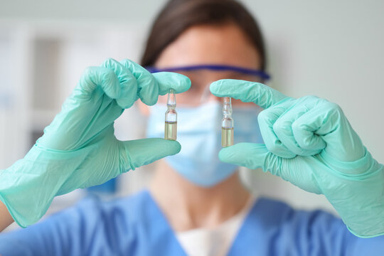 Female doctor with ampules in clinic, closeup - Powered by Adobe