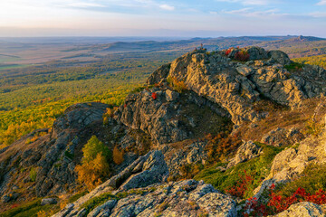 Tourists on the rock of the peak of KorotashBao on the Irendyk ridge in the Southern Urals on an...