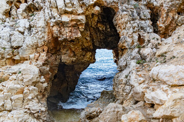Rocky arch grotto at Cala La Granadella on Mediterranean, Javea, Costa Blanca, Spain
