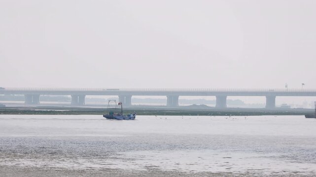 Fshing boat heading out to sea from the coastal port in Binhai, Tianjin, China.p