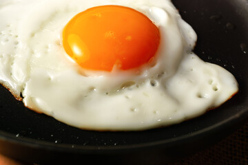 Sunny side up egg cooking in a hot non-stick pan