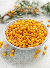 Sea buckthorn berries in bowl with branches
