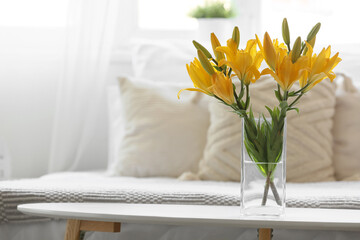 Vase with beautiful lily flowers on bedside table in bedroom, closeup