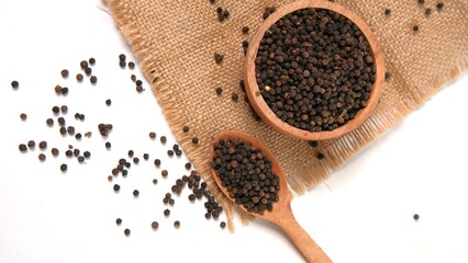 Black Peppercorns in Wooden Bowl and Spoon on Burlap