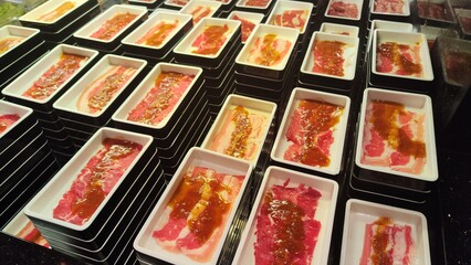 Marinated meat slices are placed on trays and ready to be served at shabu and grills restaurants. Typical Japanese restaurant