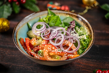 Fresh vegetable salad with onion rings and sesame seeds