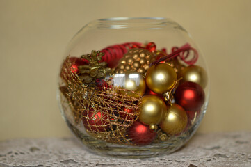 vase in a shape of glass bowl filled with shiny christmas decorations