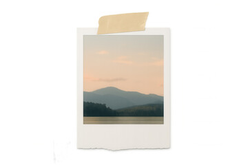 Instant print showing calm lake with mountains, embodying travel memories and cherished nostalgia