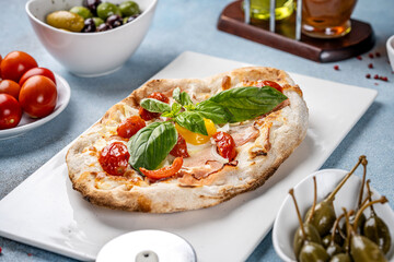 Italian flatbread with egg, tomatoes, and basil