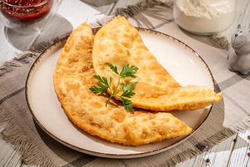 Crispy chebureki on a plate with parsley