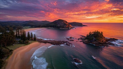 Coastal landscape with beach trees rocks and colorful sky at sunset.