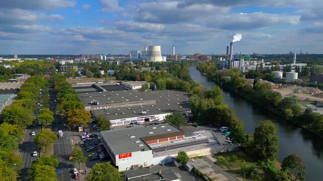 Industrial landscape with factories, a large power plant, and storage tanks bordering river in berlin germany. Fantastic aerial view flight panorama overview drone