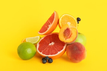 Different fresh fruits on yellow background. World Vegan Day