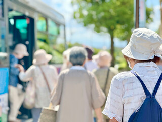 バスに乗り込むたくさんの高齢女性の後姿