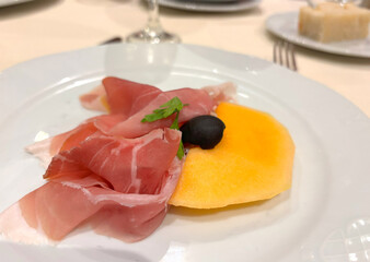 Slices of prosciutto on white plate