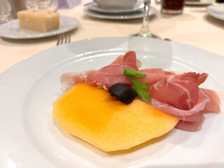 Slices of prosciutto on white plate
