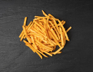 Fried chips sticks, finger potato chips, golden shoestring fries pile, French fries