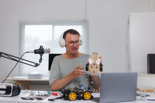 Man teaching robotics online using robot car - Powered by Adobe