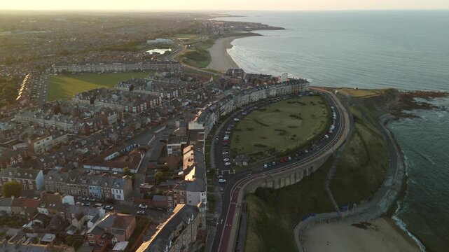Tynemouth UK 16th August 2025: Beautiful dusk view over Tynemouth King Edward's Bay with North Sea coastline and town lights glowing. Drone footage