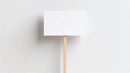 White card on stick against plain wall