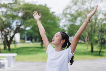 Woman raising arms enjoying freedom feeling happy