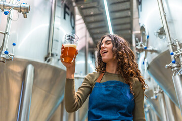 Woman tasting craft beer for quality control in brewery