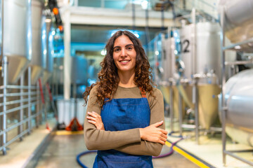 Woman brewer standing in modern craft beer factory