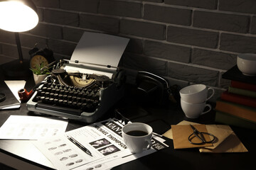 Vintage typewriter with wanted posters and fingerprints on table in dark office