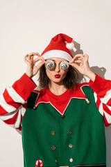 Santa elf character in festive outfit with novelty Christmas tree shaped glasses