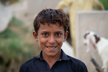 Smiling village boy standing outdoors in rural Pakistan with a joyful expression
