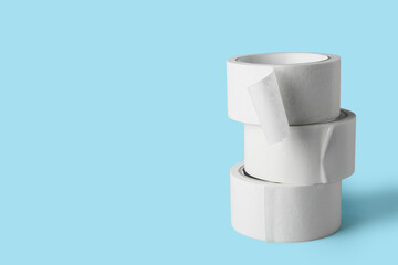 Rolls of white masking tape on blue background