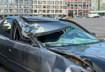 Damaged smashed grey sedan car on the street as a result of a traffic accident is ready for...