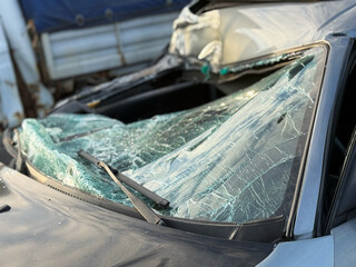 Damaged smashed grey sedan car on the street as a result of a traffic accident is ready for...