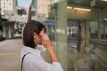 Fototapeta premium Woman in business attire fixing her hairstyle while looking at her reflection