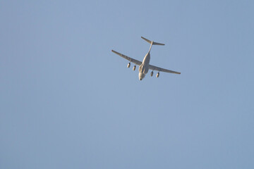 A large transport plane is flying in the sky on a sunny day