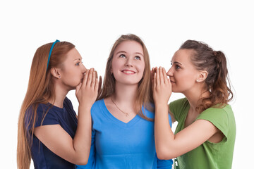 Three Young Funny Caucasian Girlfriends Sharing Their Secrets Whispering to Ears.Isolated Over White Background.