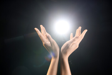 Female hands with ball of energy on black background