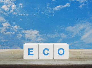 Eco letter on white block cubes on wooden table over blue sky with white clouds, Business ecological concept