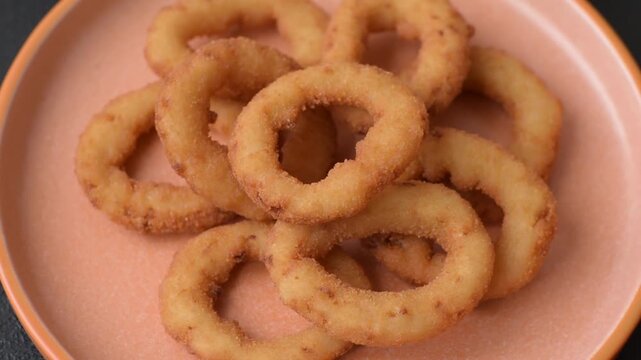 Onion rings or fried squid in breadcrumbs with sauce, takeaway food. Onion rings fried, fast food as a background for your design