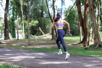 Woman running on path, exercising outdoors for fitness