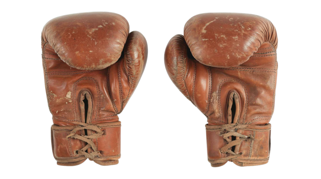 A pair of well worn vintage brown leather boxing gloves displaying extensive scuffs and distressed texture isolate