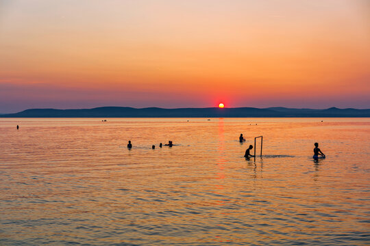 People playing water polo at sunset in Lake Balaton in Hungary